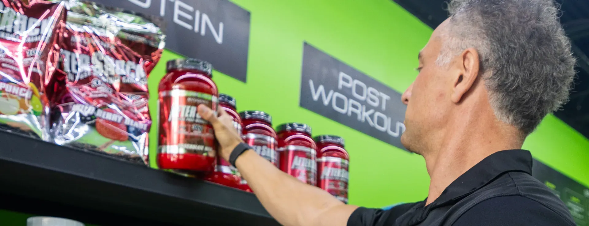 Elite Nutrition team member stocking the protein and post-workout wall